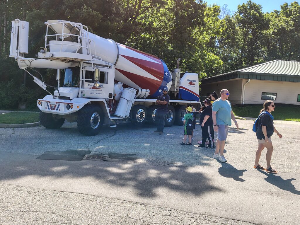 Families observing a large cement truck
