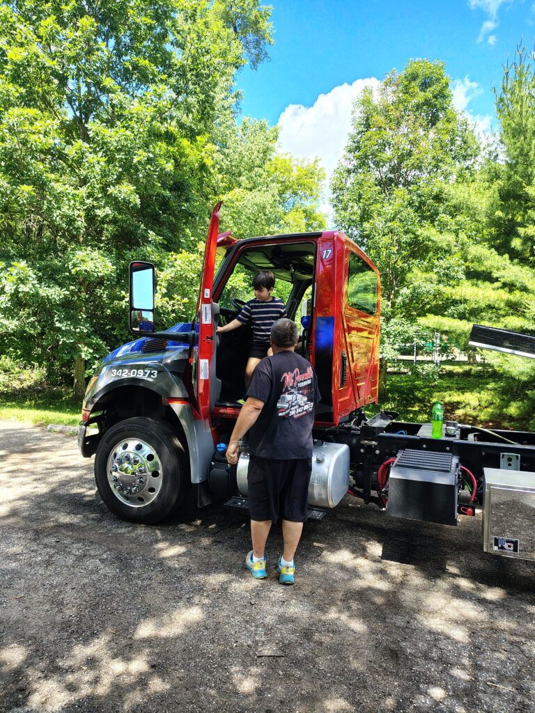 Kid sitting in the seat of a large tow truck